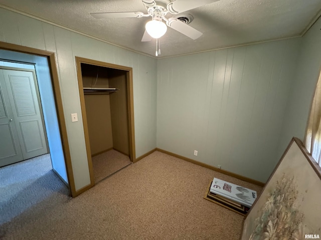 unfurnished bedroom featuring a textured ceiling, light colored carpet, and ceiling fan