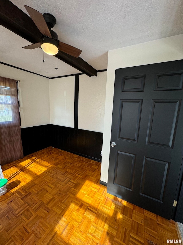 empty room featuring a textured ceiling, light parquet floors, and ceiling fan