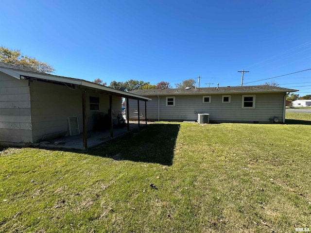 rear view of house with a patio, central AC, and a lawn