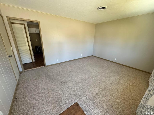 carpeted spare room with a textured ceiling