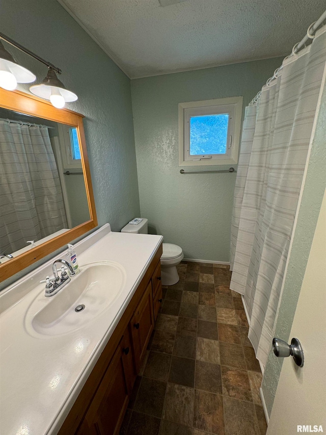 bathroom featuring vanity, toilet, and a textured ceiling