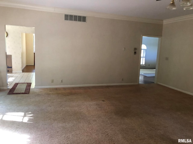 carpeted spare room featuring crown molding and ceiling fan