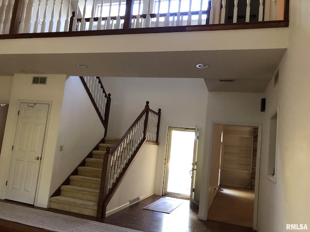 foyer entrance featuring a towering ceiling and hardwood / wood-style floors