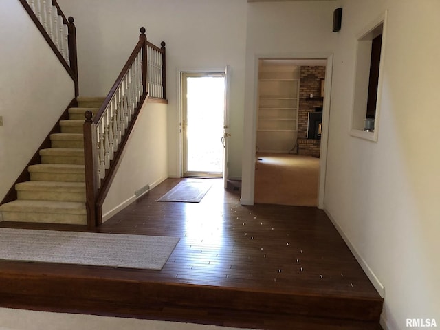 foyer featuring dark hardwood / wood-style floors and a fireplace