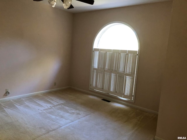 spare room with ceiling fan and light colored carpet