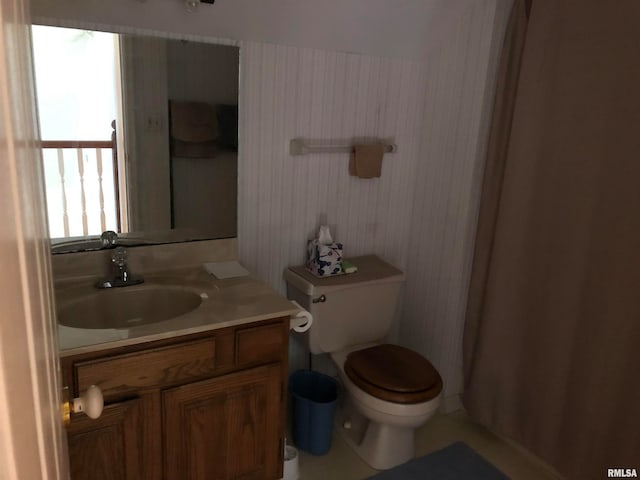 bathroom featuring toilet, vanity, and a shower with shower curtain