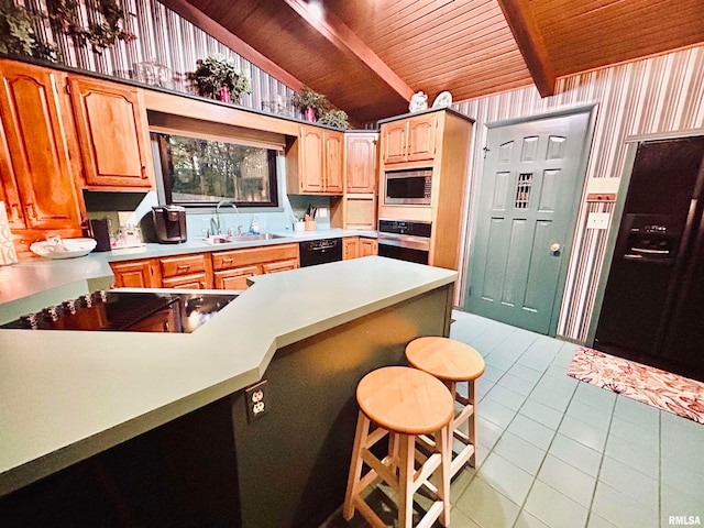 kitchen featuring a breakfast bar, light tile patterned flooring, stainless steel appliances, and lofted ceiling with beams