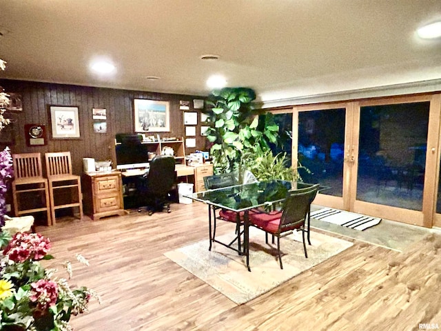 office area with wooden walls and hardwood / wood-style flooring