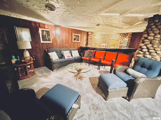 carpeted living room with wood walls and a textured ceiling