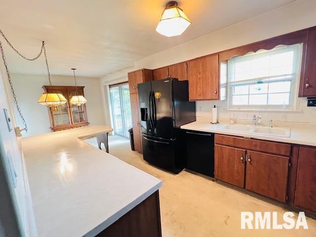 kitchen featuring black appliances, sink, pendant lighting, and a wealth of natural light