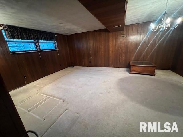 basement with wooden walls and light colored carpet