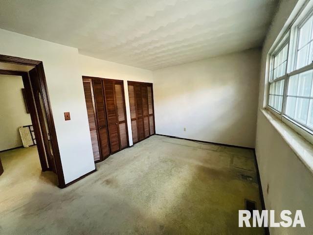 25 SW Crescent Rd, Mount Vernon, IL 62864 - unfurnished bedroom featuring light colored carpet and two closets