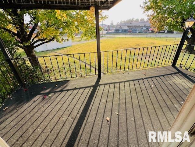 wooden deck featuring a lawn