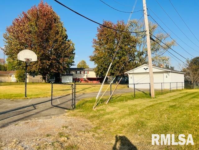 view of yard featuring basketball court, an outbuilding, and a garage