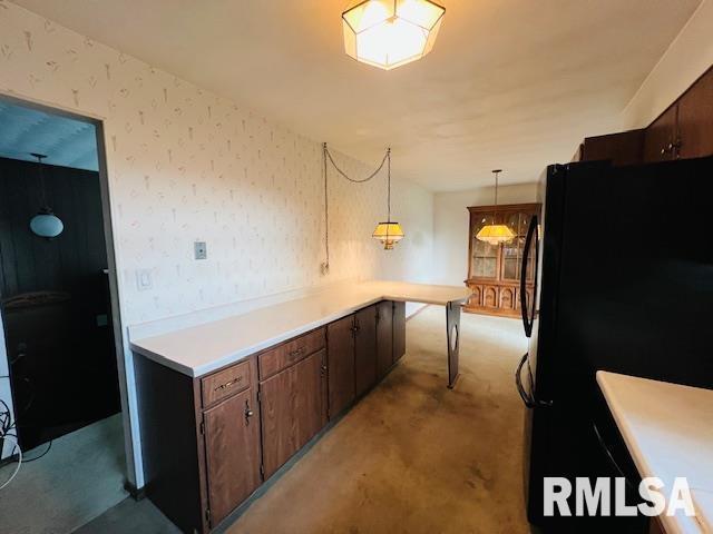 25 SW Crescent Rd, Mount Vernon, IL 62864 - kitchen with freestanding refrigerator, light colored carpet, wallpapered walls, light countertops, and dark brown cabinets