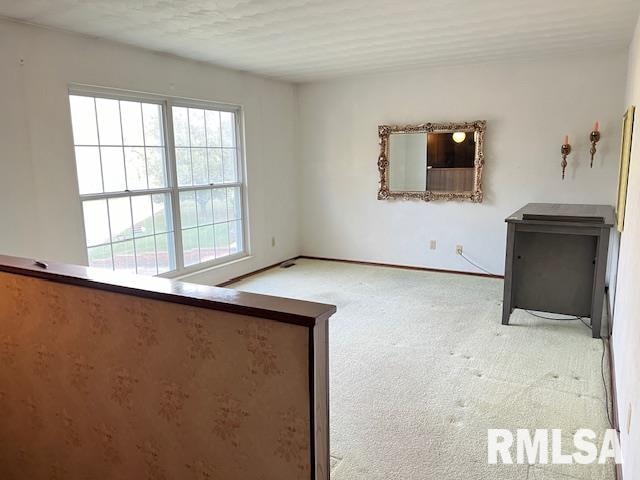 unfurnished room featuring light colored carpet