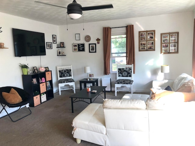 living room featuring ceiling fan, a textured ceiling, and dark colored carpet