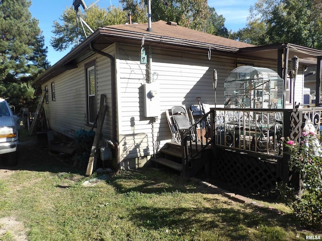 exterior space with a deck and a lawn