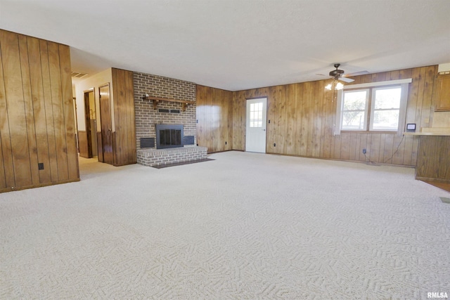 unfurnished living room featuring light carpet, a fireplace, and ceiling fan