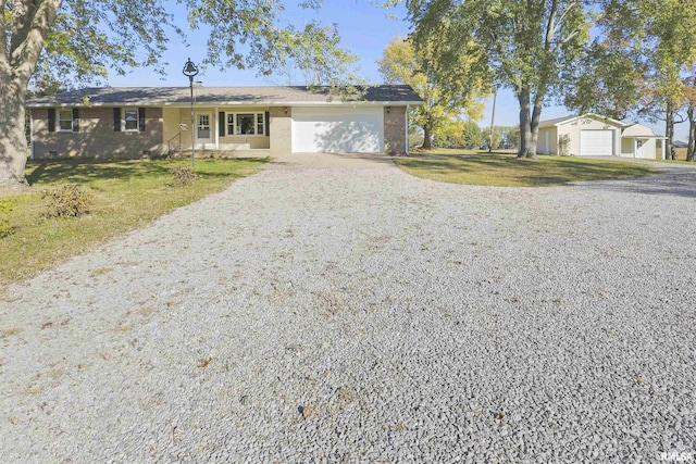 single story home with covered porch, a front lawn, and a garage