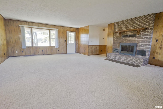 unfurnished living room with wood walls and carpet