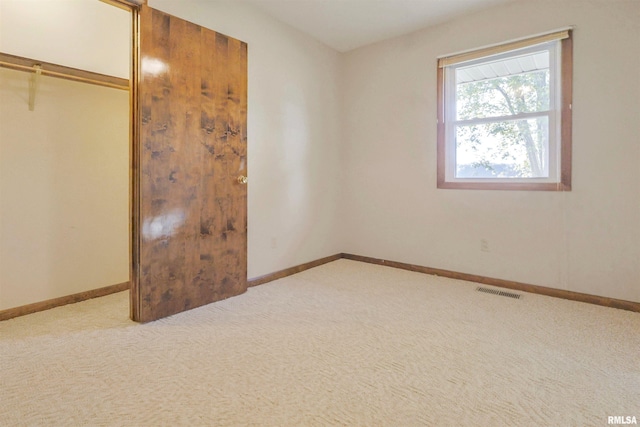 unfurnished bedroom featuring a closet and light carpet