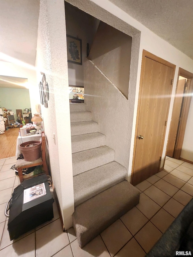 stairs featuring tile patterned flooring