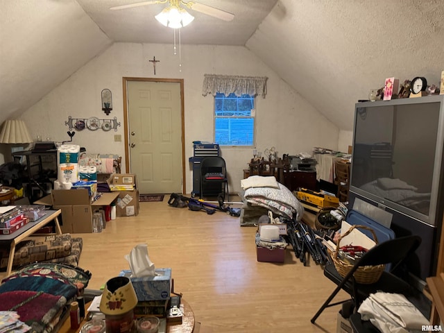 bonus room with lofted ceiling, a textured ceiling, hardwood / wood-style flooring, and ceiling fan