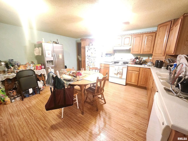 kitchen with light hardwood / wood-style flooring, stainless steel refrigerator with ice dispenser, a textured ceiling, and white electric stove