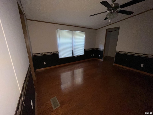 spare room featuring a textured ceiling, ceiling fan, and dark hardwood / wood-style floors