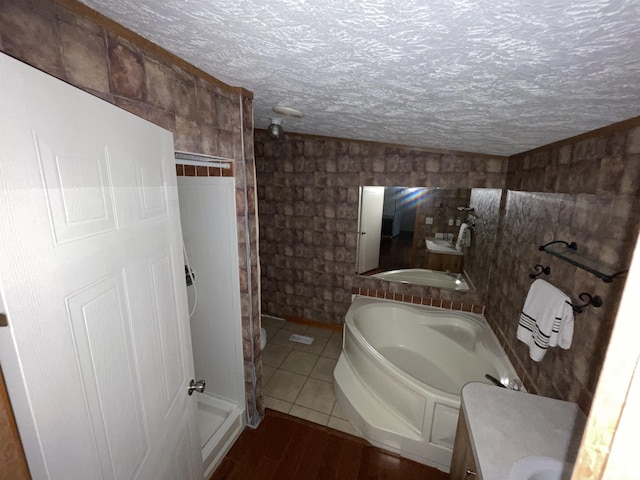 bathroom featuring vanity, a textured ceiling, independent shower and bath, and tile patterned flooring