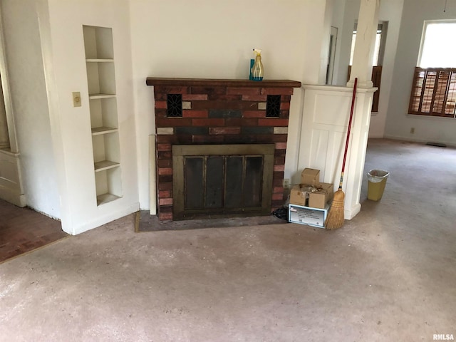 unfurnished living room with concrete floors, a fireplace, and built in features