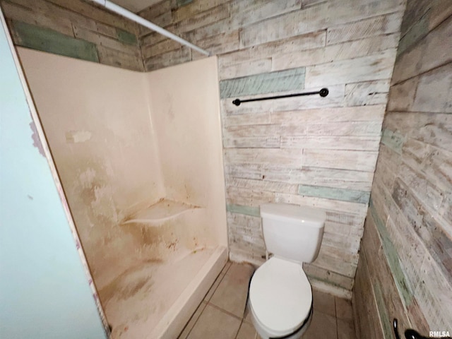 bathroom with tile patterned flooring, toilet, and walk in shower