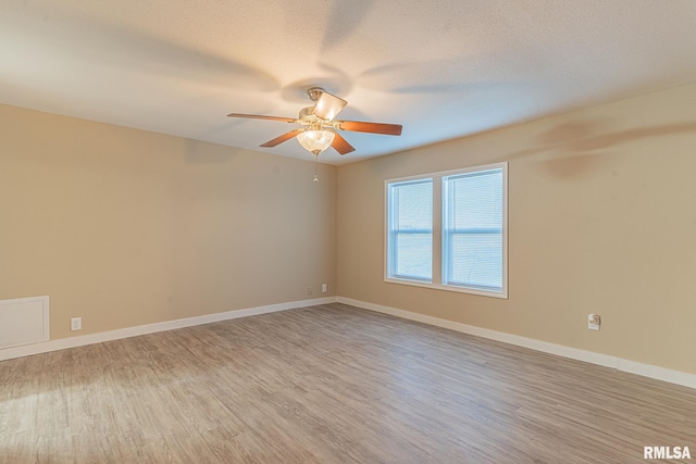 empty room featuring ceiling fan, a textured ceiling, and light wood-type flooring