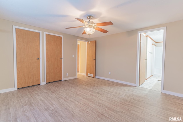 unfurnished bedroom with two closets, light wood-type flooring, and ceiling fan