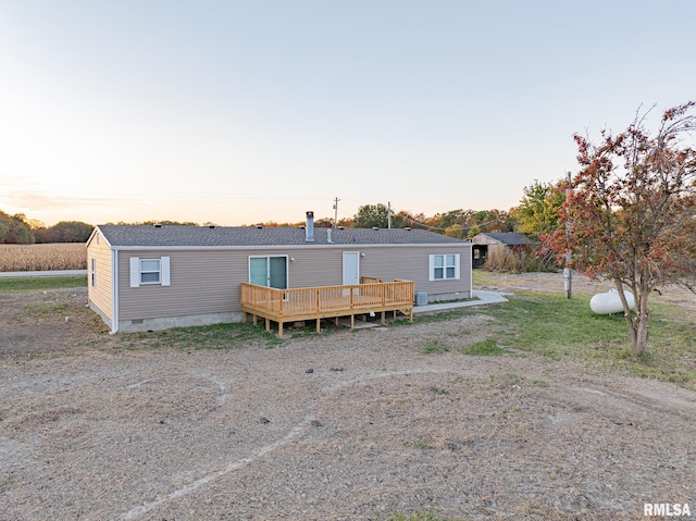 back house at dusk with a wooden deck