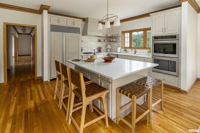 5345 State Route 127th Hwy, Cobden, IL 62920 - kitchen with stainless steel appliances, a sink, crown molding, a breakfast bar, and light wood-style floors