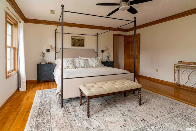 bedroom with ornamental molding, light hardwood / wood-style floors, and ceiling fan