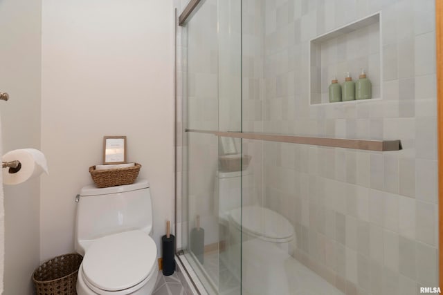 bathroom featuring toilet and an enclosed shower