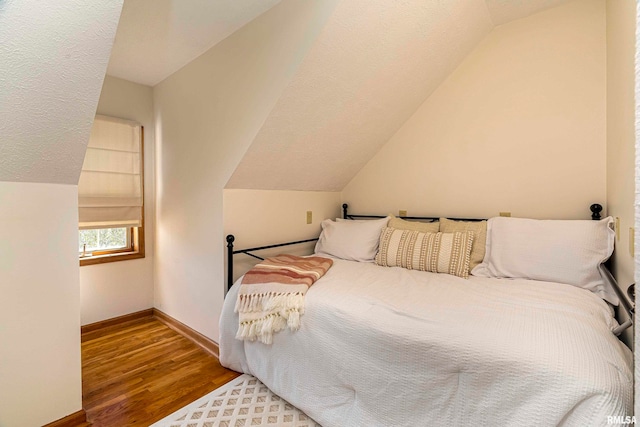 bedroom with lofted ceiling and hardwood / wood-style floors