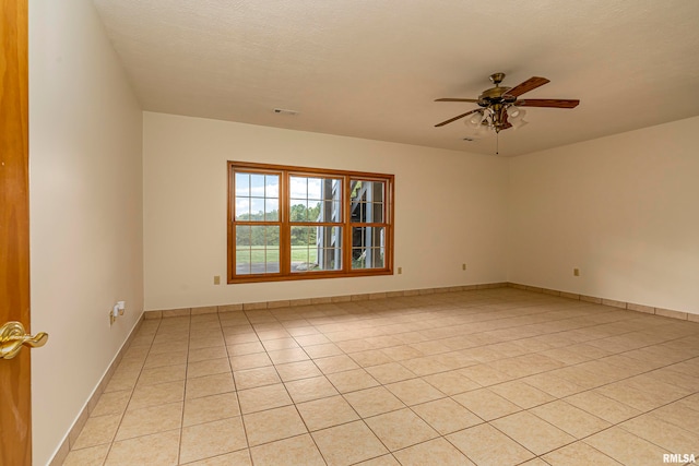 tiled spare room with ceiling fan and a textured ceiling