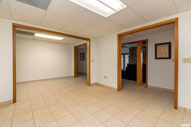 spare room with light tile patterned flooring and a paneled ceiling