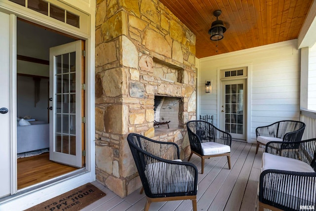 deck with an outdoor stone fireplace