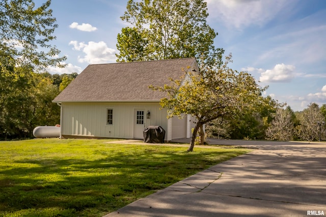 rear view of property with a yard and a garage