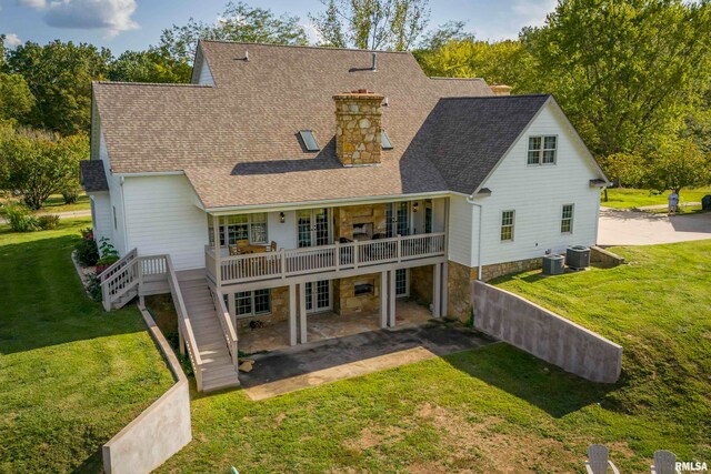 rear view of property featuring a yard, a patio, and central AC