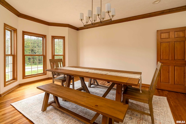 dining space featuring crown molding, wood-type flooring, and an inviting chandelier