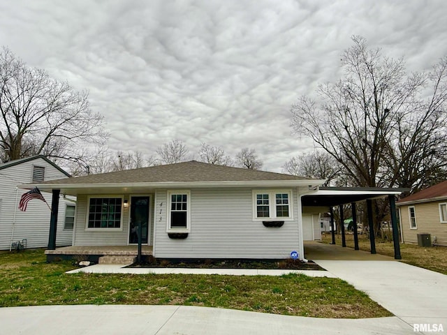 view of front of property with concrete driveway, an attached carport, a porch, and a front yard