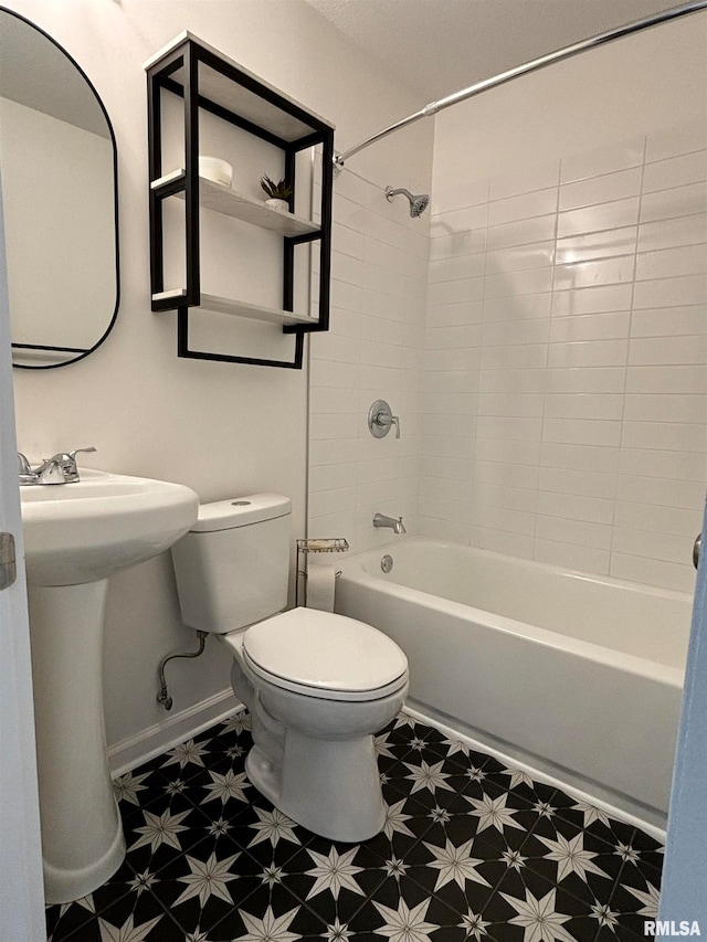 bathroom with toilet and tiled shower / bath combo