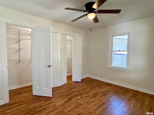 unfurnished bedroom with dark hardwood / wood-style flooring, a closet, and ceiling fan