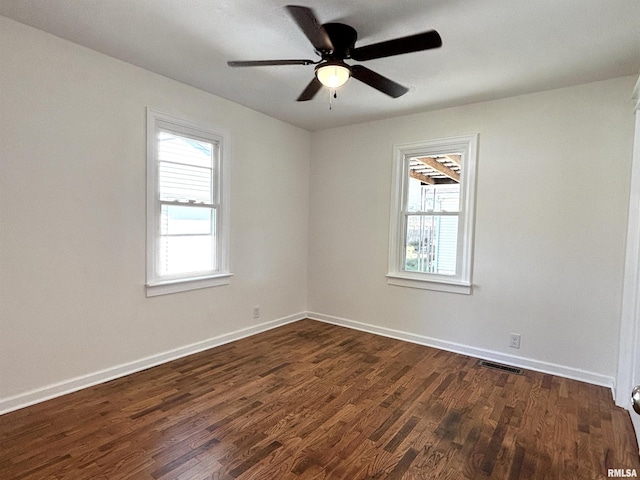 unfurnished room with dark wood-style floors, ceiling fan, visible vents, and baseboards